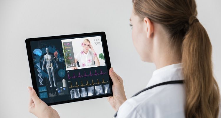 A nurse talking through her tablet with a patient