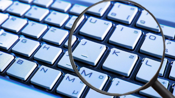 a keyboard being zoomed with a magnifying glass