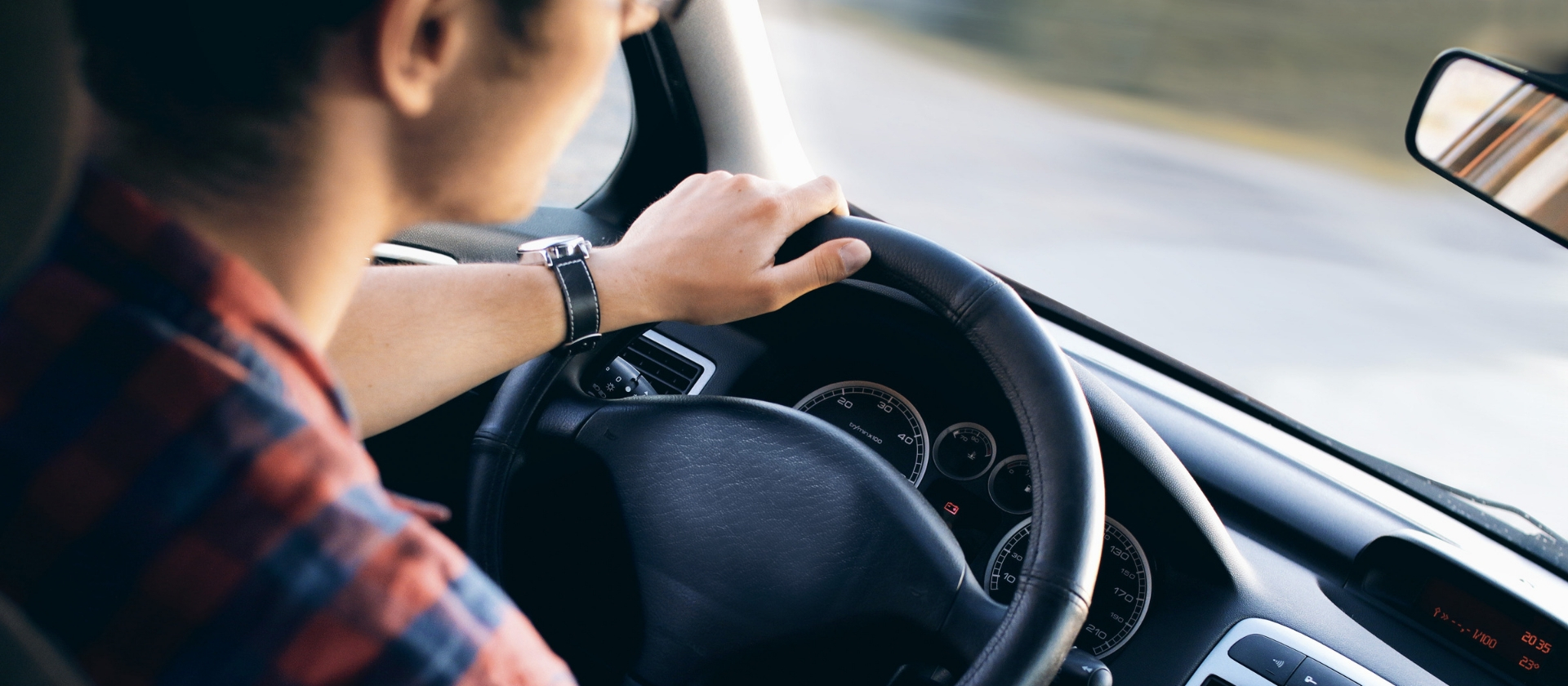 A man driving a car with both hands